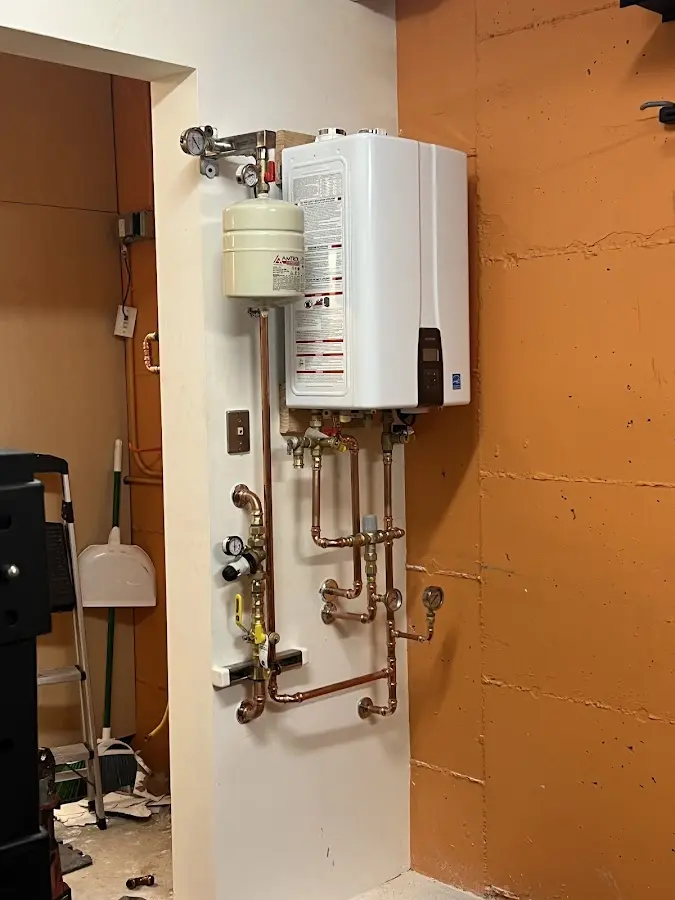 Plumbing technician inspecting water heater connections in Rye Brook